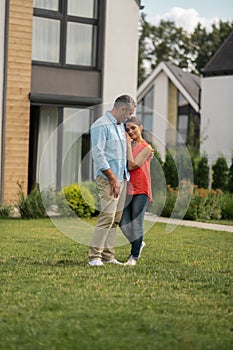 Couple standing outside near their cottage house at the weekend