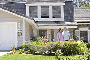 Couple Standing Outside Their House