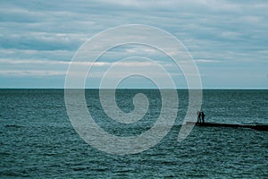 Couple standing on the pier. Black Sea. minimalism