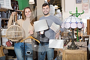 couple standing with purchases in furnishings salon