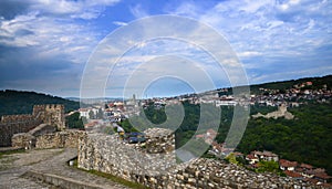 Couple standing at the ruins of the old fortress and looking at Cityscape of Plovdiv city, Bulgaria. Panoramic View over skyline.