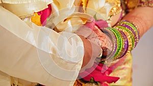 Couple standing together dressed in traditional Indian clothes, hindu wedding. Close up shot of couples