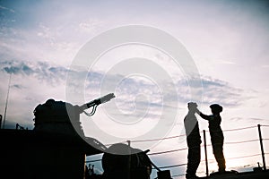 A couple standing on a warship with cannon silhouette background,