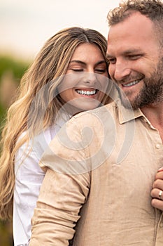 couple stands embraced in a warm, loving hug, their faces beaming with happiness and joy. Their love is evident in the way they