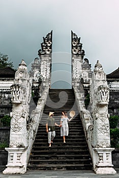 A couple stands on the stairs of the Baltic temple. Man and woman traveling in Indonesia. Couple at the Bali gate.