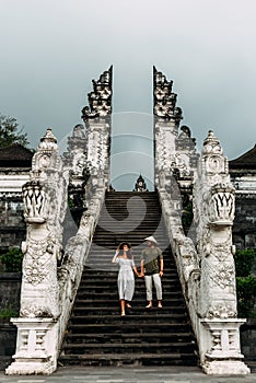A couple stands on the stairs of the Baltic temple. Man and woman traveling in Indonesia. Couple at the Bali gate.