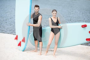 Couple with standup paddleboard on the beach