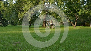 The couple stops and gets off the tandem bike to walk on the grass in the park