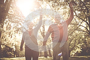 Couple stretching arms and exercising together in meadow