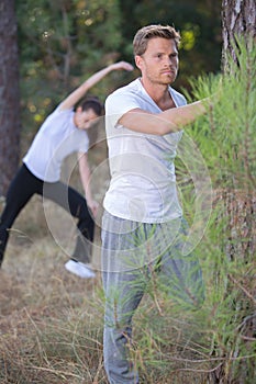 Couple stretching outdoors in forest