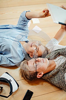 Couple studying while lying on floor at home