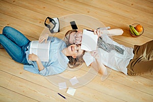 Couple studying while lying on floor at home