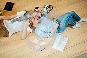 Couple studying while lying on floor at home