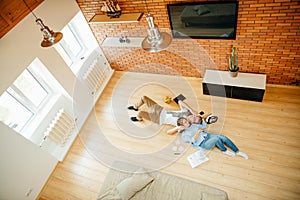 Couple studying while lying on floor at home