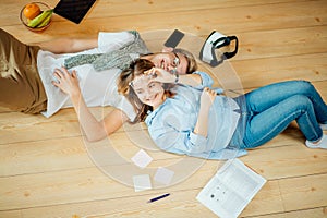 Couple studying while lying on floor at home