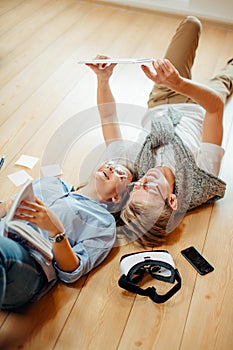 Couple studying while lying on floor at home