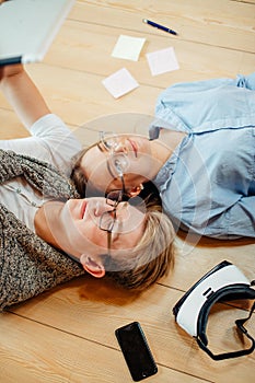 Couple studying while lying on floor at home