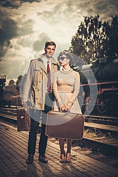 Couple with suitcases on train station platform