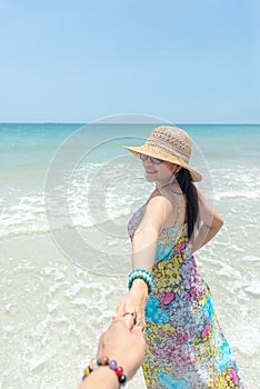 Couple summer vacation travel, Woman walking on romantic honeymoon and relax on sand beach in holidays holding hand of boyfriend f
