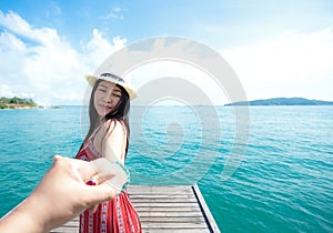 Couple summer vacation travel, Woman walking on romantic honeymoon and relax on the wood bridge near beach in holidays holding han