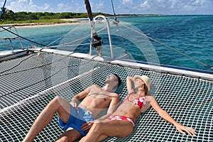 Couple sunbathing on a catamaran's net