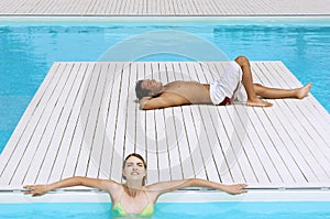 Couple Sunbathing At Poolside