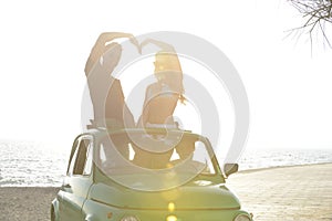 Couple at sundown on the beach with car
