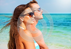 Glückliches Paar mit Sonnenbrille am Strand.