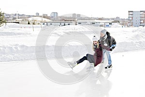 Couple in sunny winter nature ice skating