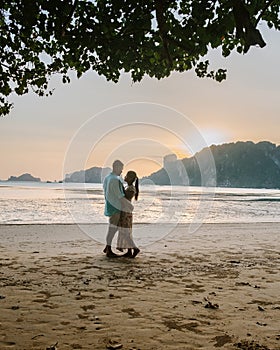 Couple during sunset on the beach Krabi Thailand, men and woman watching sunset at Ao Nam Mao beach Krabi Ao Nang area