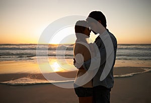 Couple, sunset and hugging on beach vacation, love and bonding on trip to ocean at dusk. People, embrace and romance on