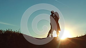 Couple at sunset silhouette kiss hugging. slow motion video. young couple kissing at sunset. man and girl meet each