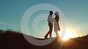 Couple at sunset silhouette kiss hugging. slow motion video. young couple kissing at sunset. man and girl meet each