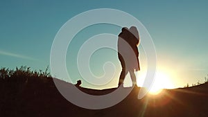 Couple at sunset silhouette kiss hugging. Slow motion video. Young couple kissing at sunset. Man and girl meet each
