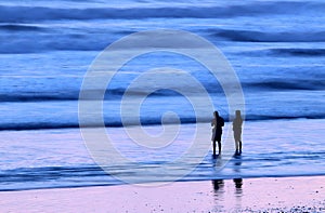 Couple surf fishing at beach with abstract background of waves on beach