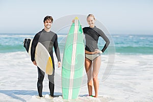 Couple with surfboard standing on the beach