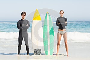 Couple with surfboard standing on the beach