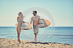 Couple of surfers walking on the beach Summer outdoor lifestyle.