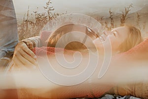 Couple in sweaters chilling and hugging on blanket outdoors in