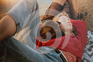 Couple in sweaters chilling and hugging on blanket outdoors in