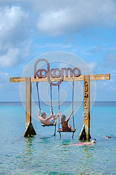 Couple at a swing in the ocean of Curacao Caribbean Island, Kokomo Beach Curacao
