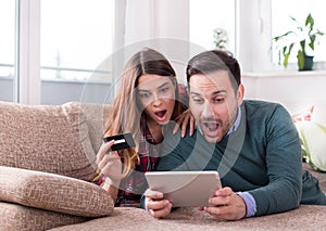 Couple with tablet and credit card at home