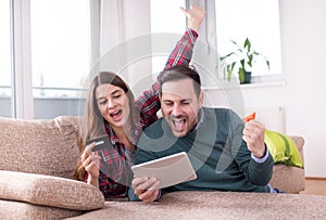 Couple with tablet and credit card at home