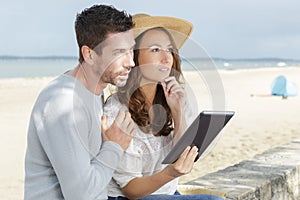 Couple with tablet by seaside outdoor