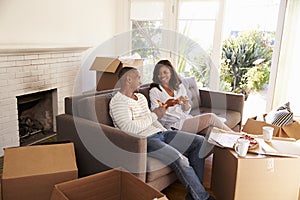 Couple Take A Break On Sofa With Pizza On Moving Day