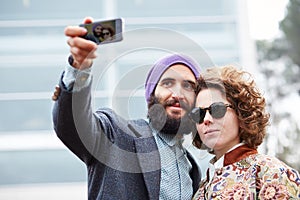 Couple taking a photograph of themselves with a smartphone