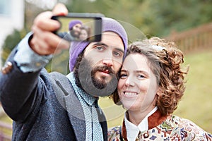 Couple taking a photograph of themselves with a smartphone