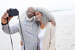 Couple taking a picture with digital camera on the beach
