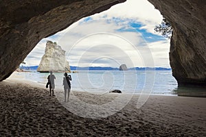 Couple taking pictures at scenic Cathedral Cove New Zealand