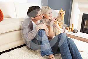 Couple Taking Playing With Pet Cat At Home